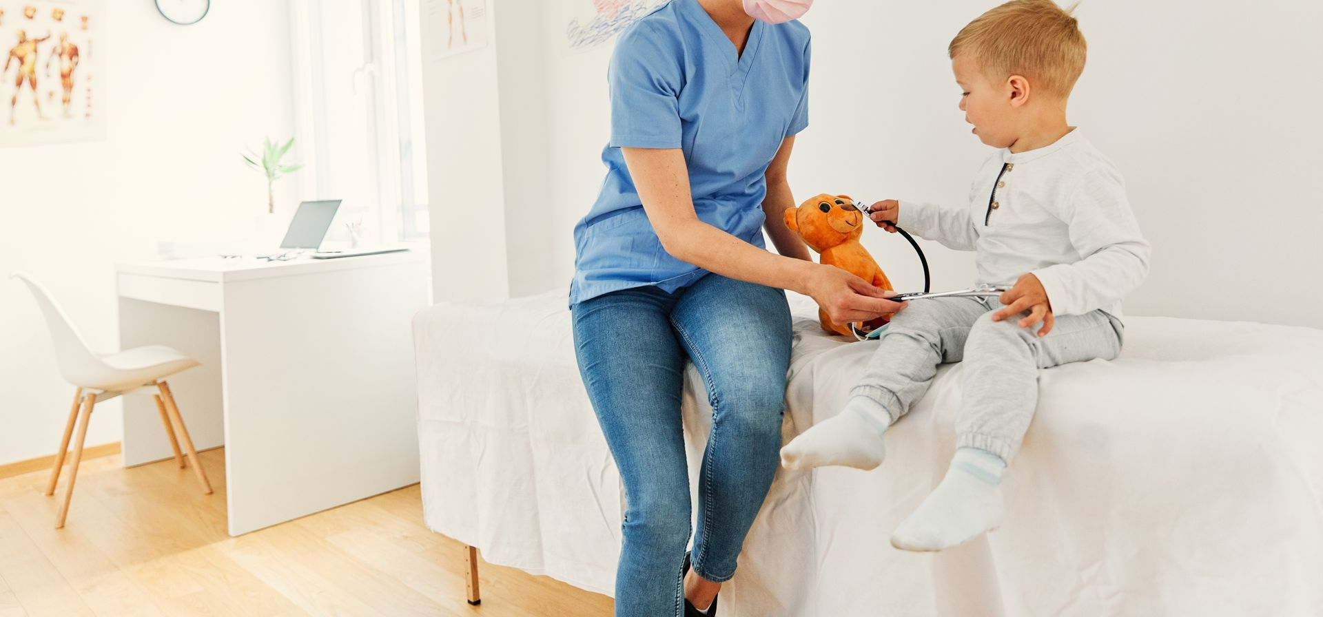 Une infirmière avec un enfant et sa peluche