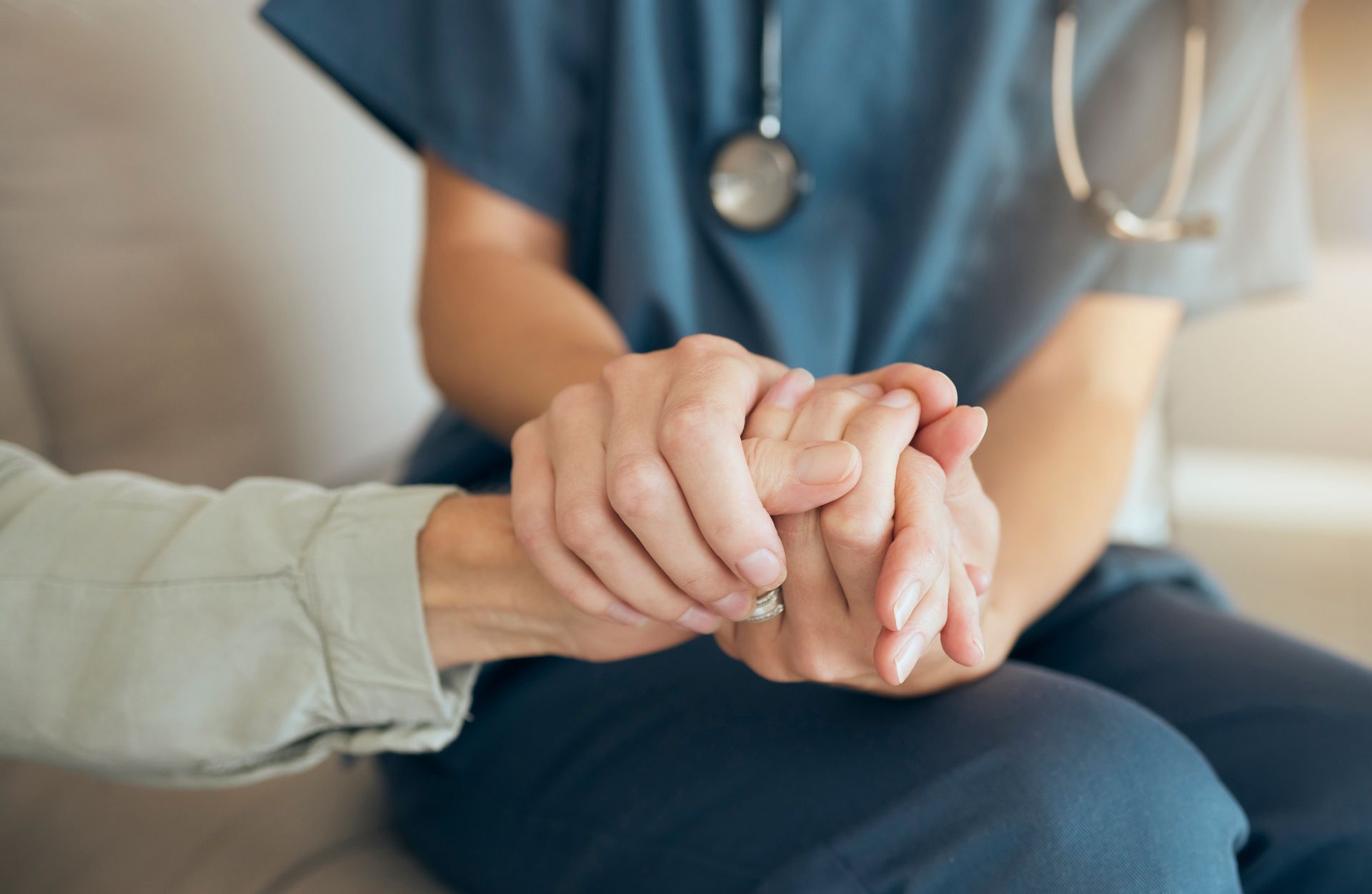 Une infirmière en blouse qui tient la main d'une patiente