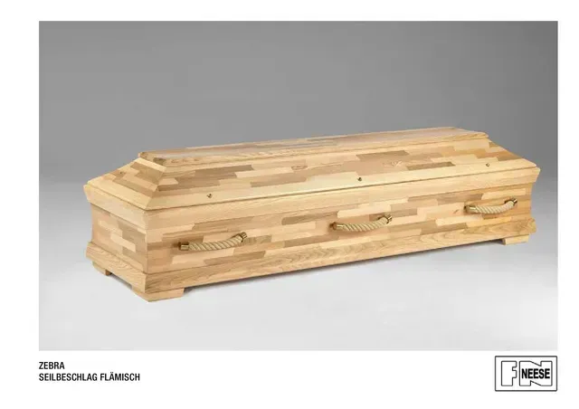 Zebra-Seilbeschlag-Flaemisch | Holzsarg mit schrägem Deckel und gestuften Seiten auf schlichtem grauen Hintergrund