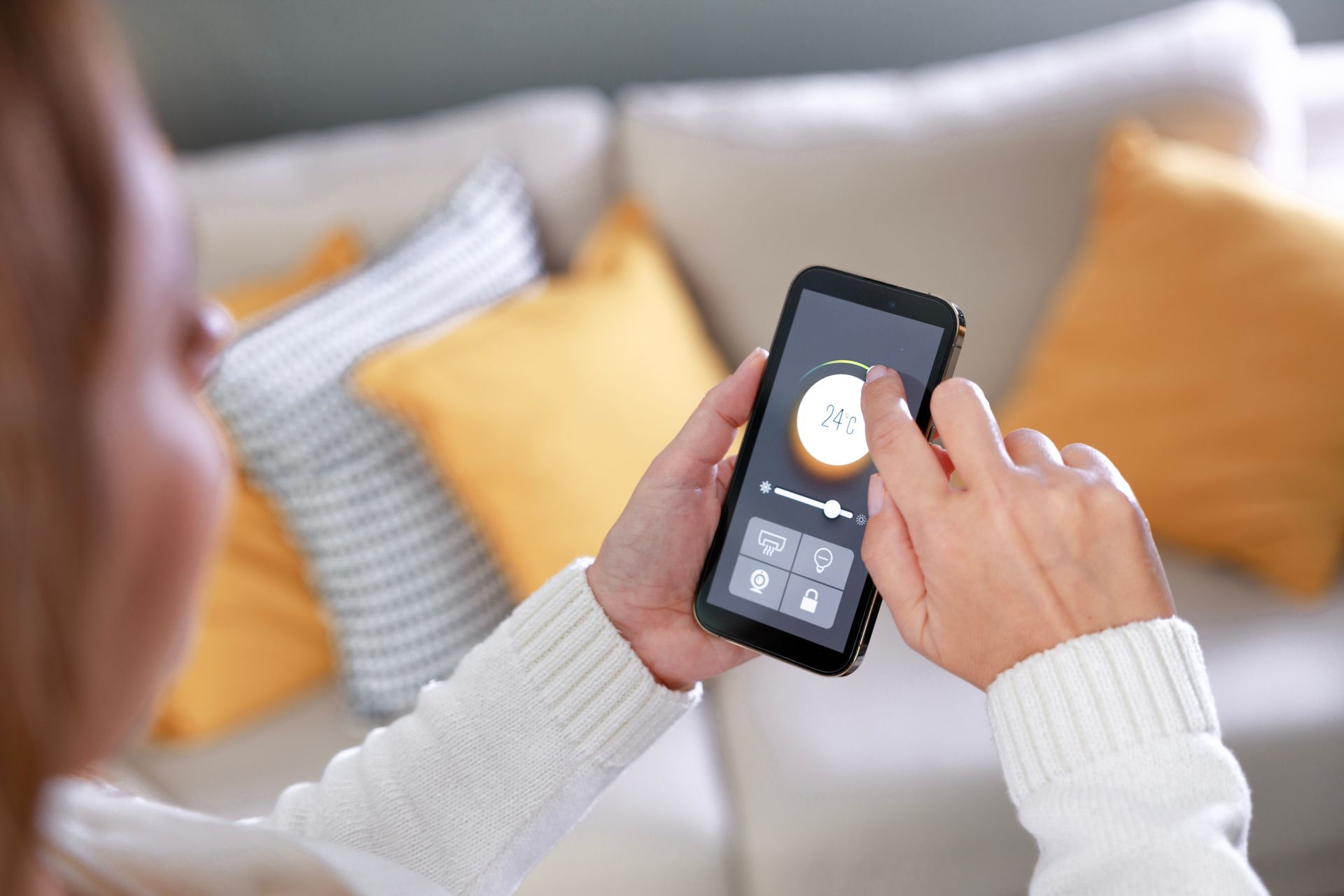 Donna controlla impianto domotico tramite smartphone