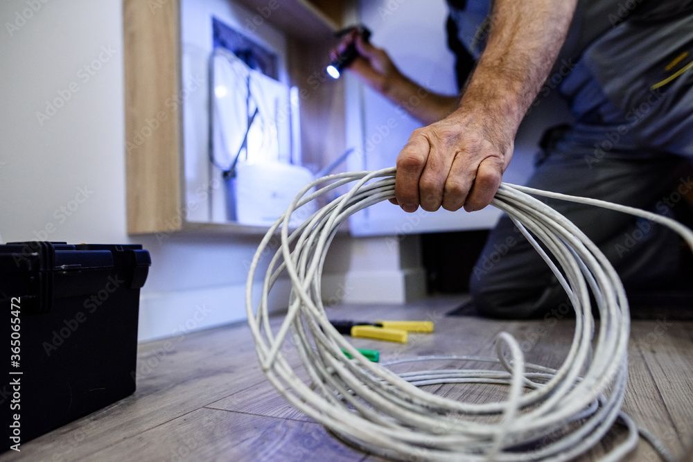 Uomo mantiene un tubo elettrico arrotolato