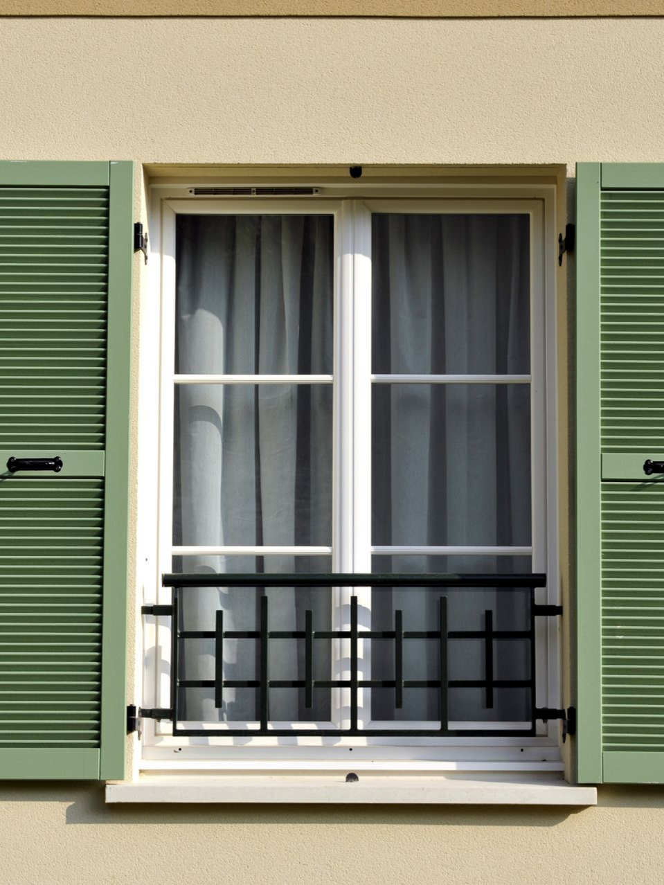 Fenêtre battante aux volets verts