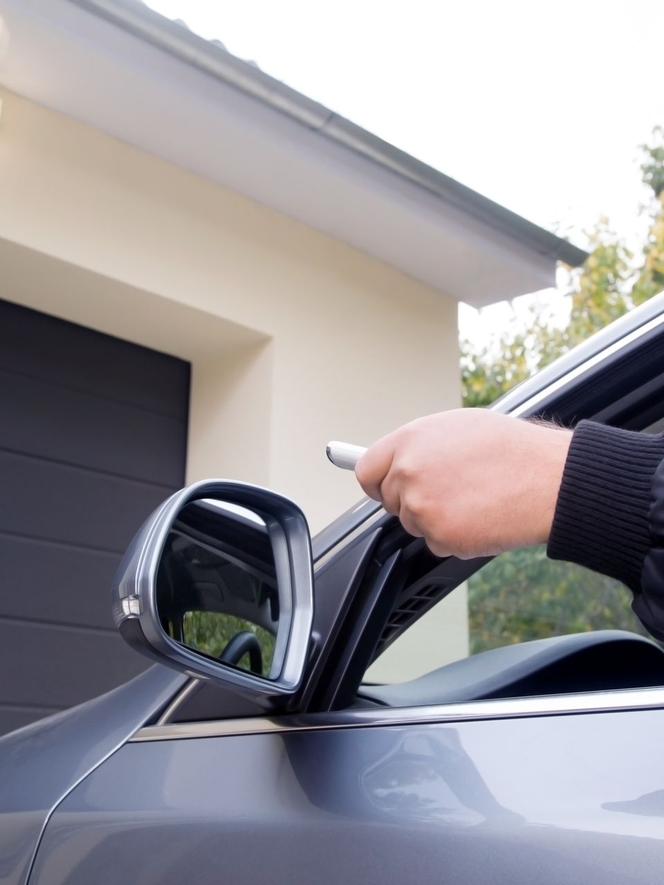 Conducteur appuyant sur la commande d'ouverture de son garage