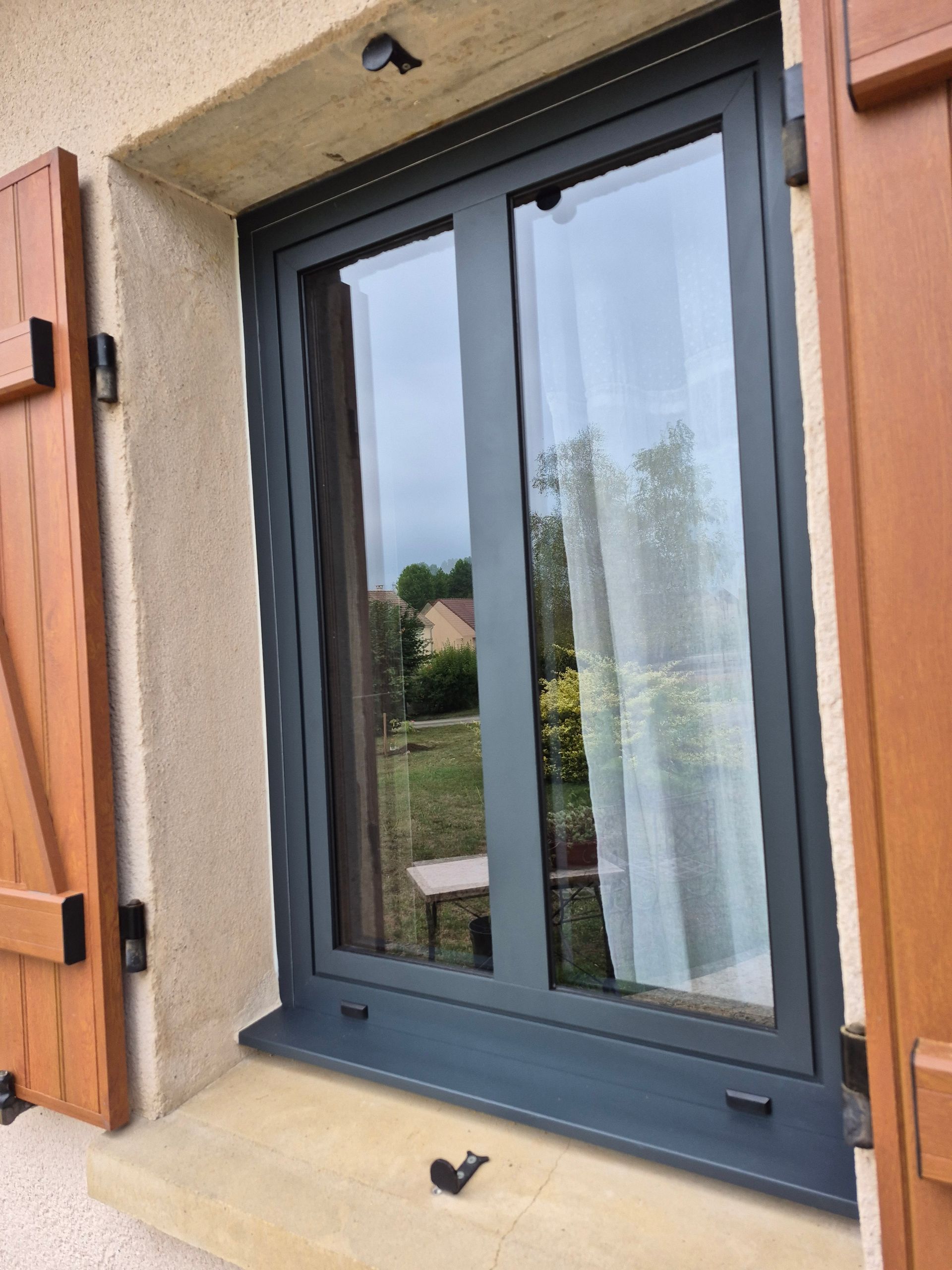 Volets battants marron et fenêtre coulissante