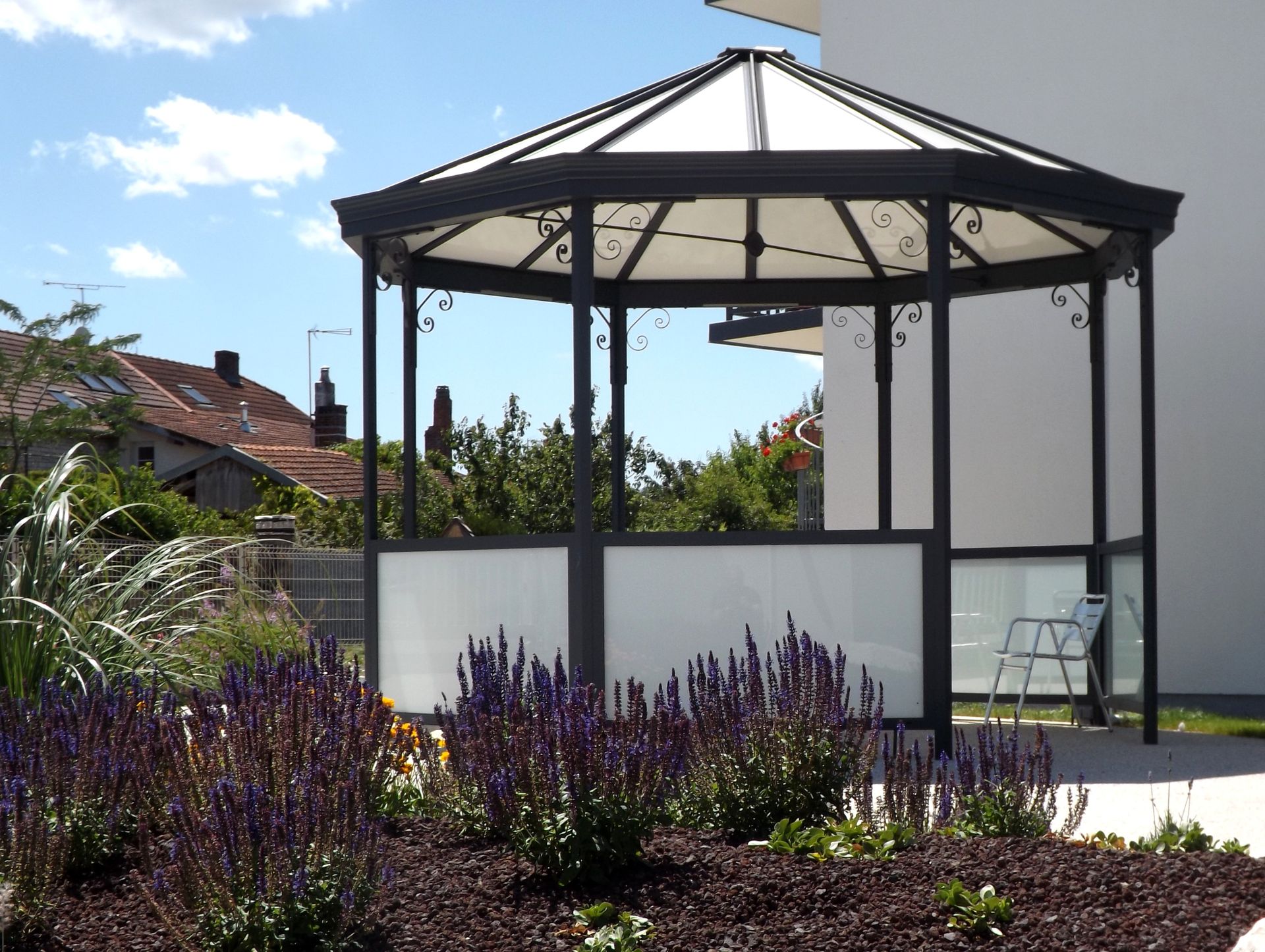 Un kiosque en métal noir avec un toit blanc
