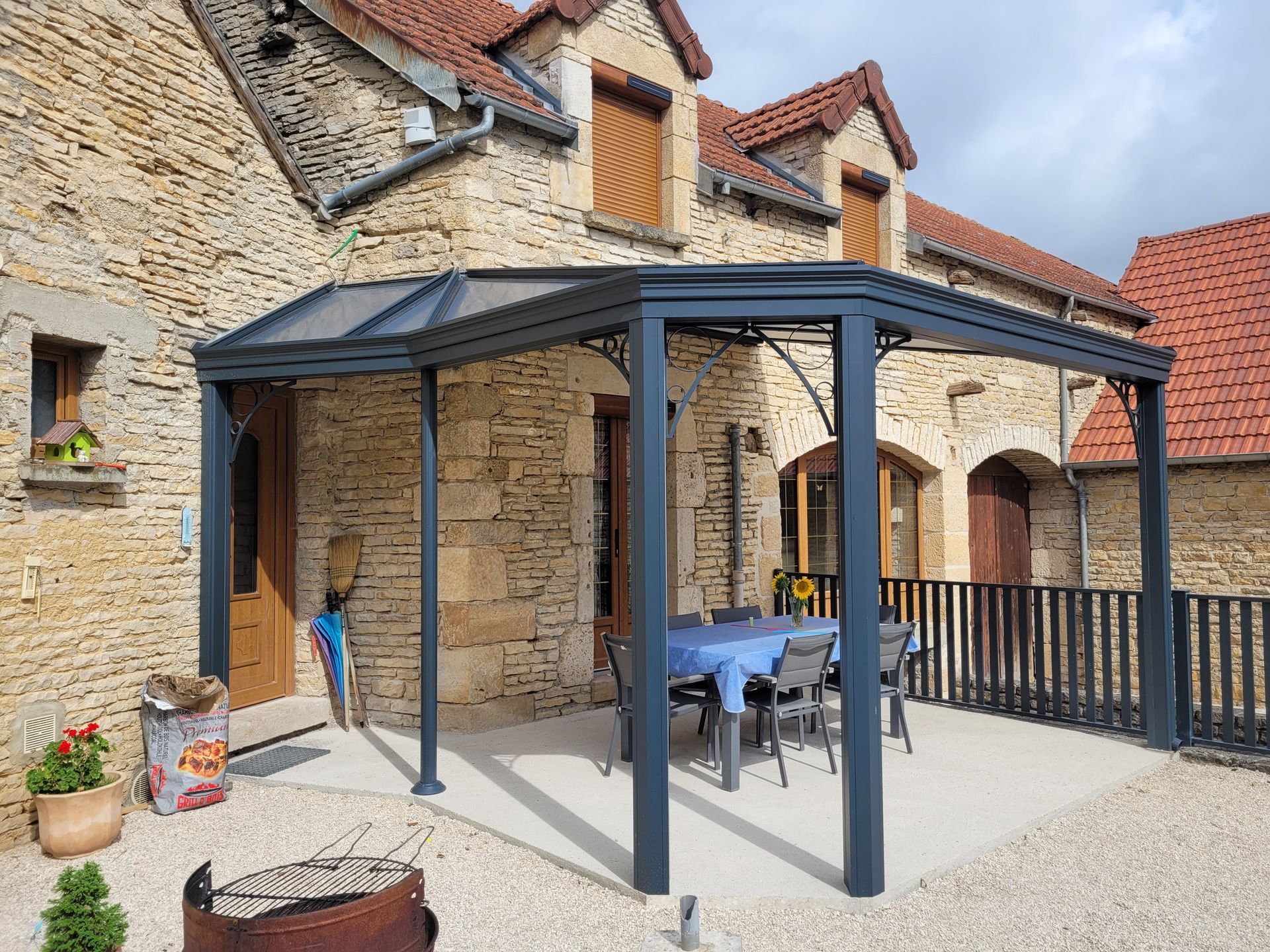 Pergola adossée à une maison en pierre
