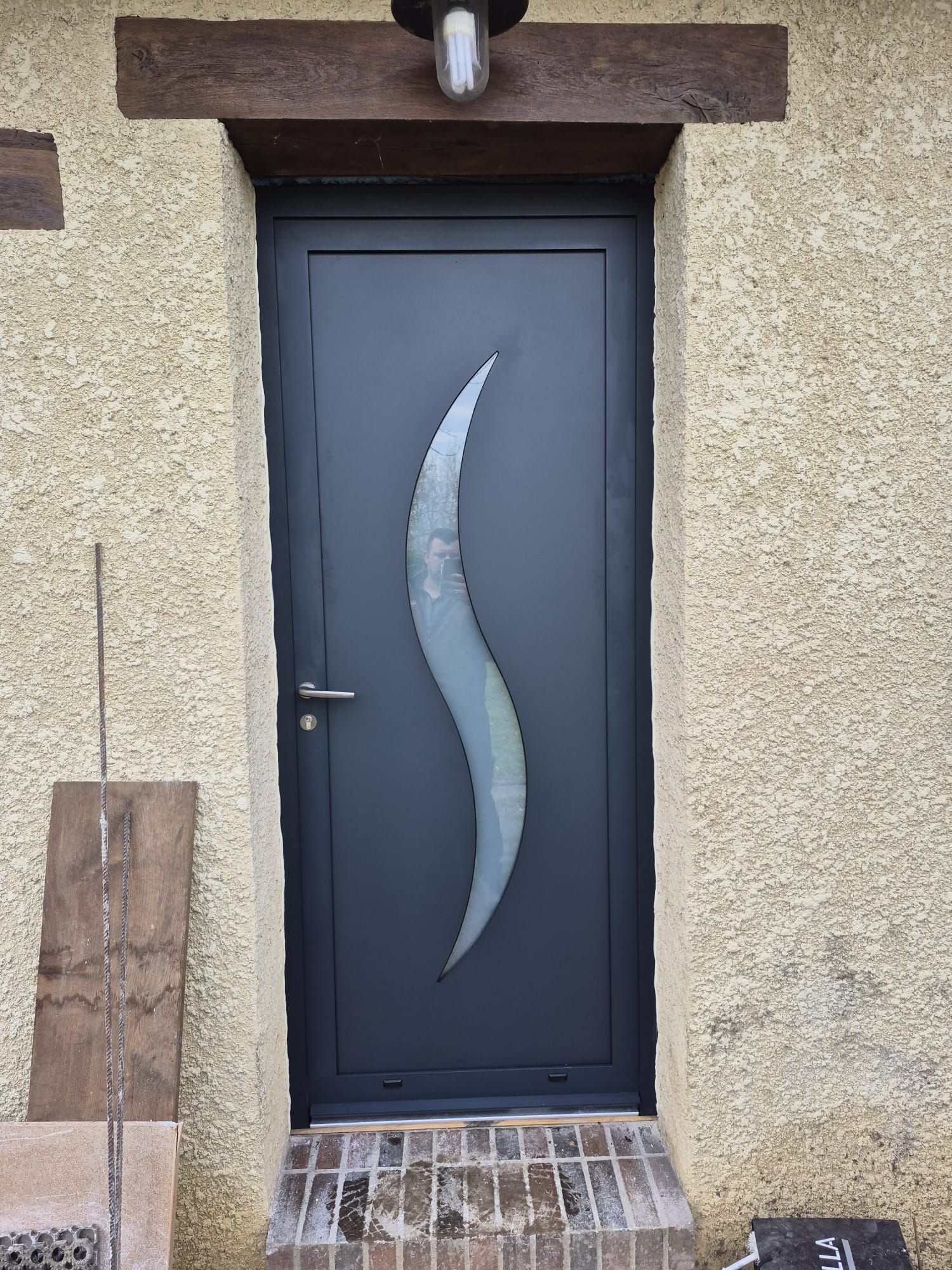 Porte extérieure gris foncé avec vitrage incurvé