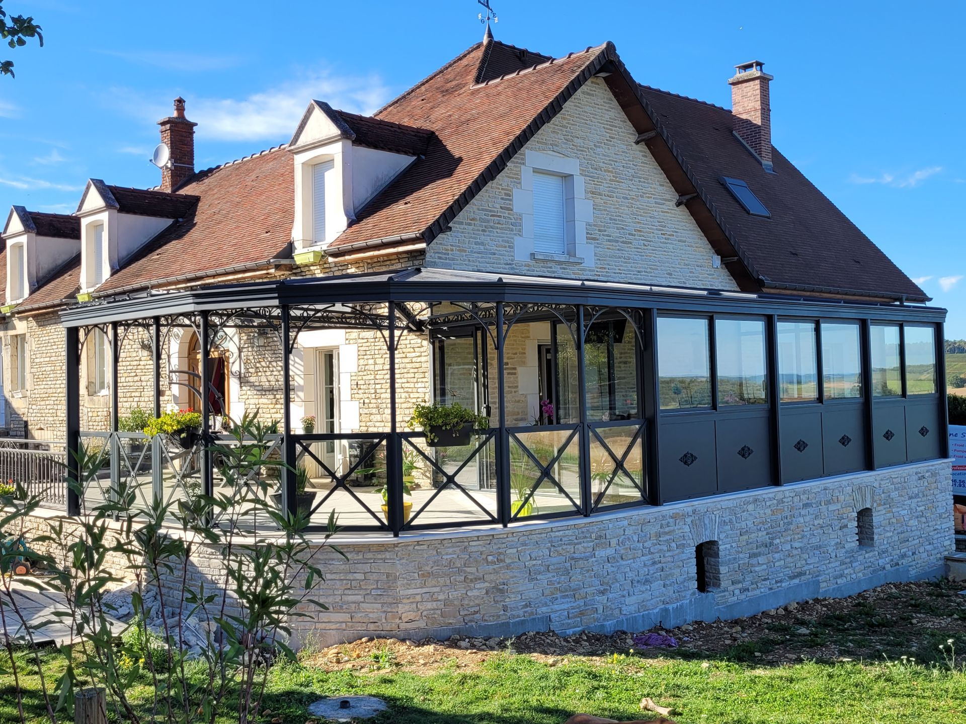 Maison en pierre avec véranda vitrée