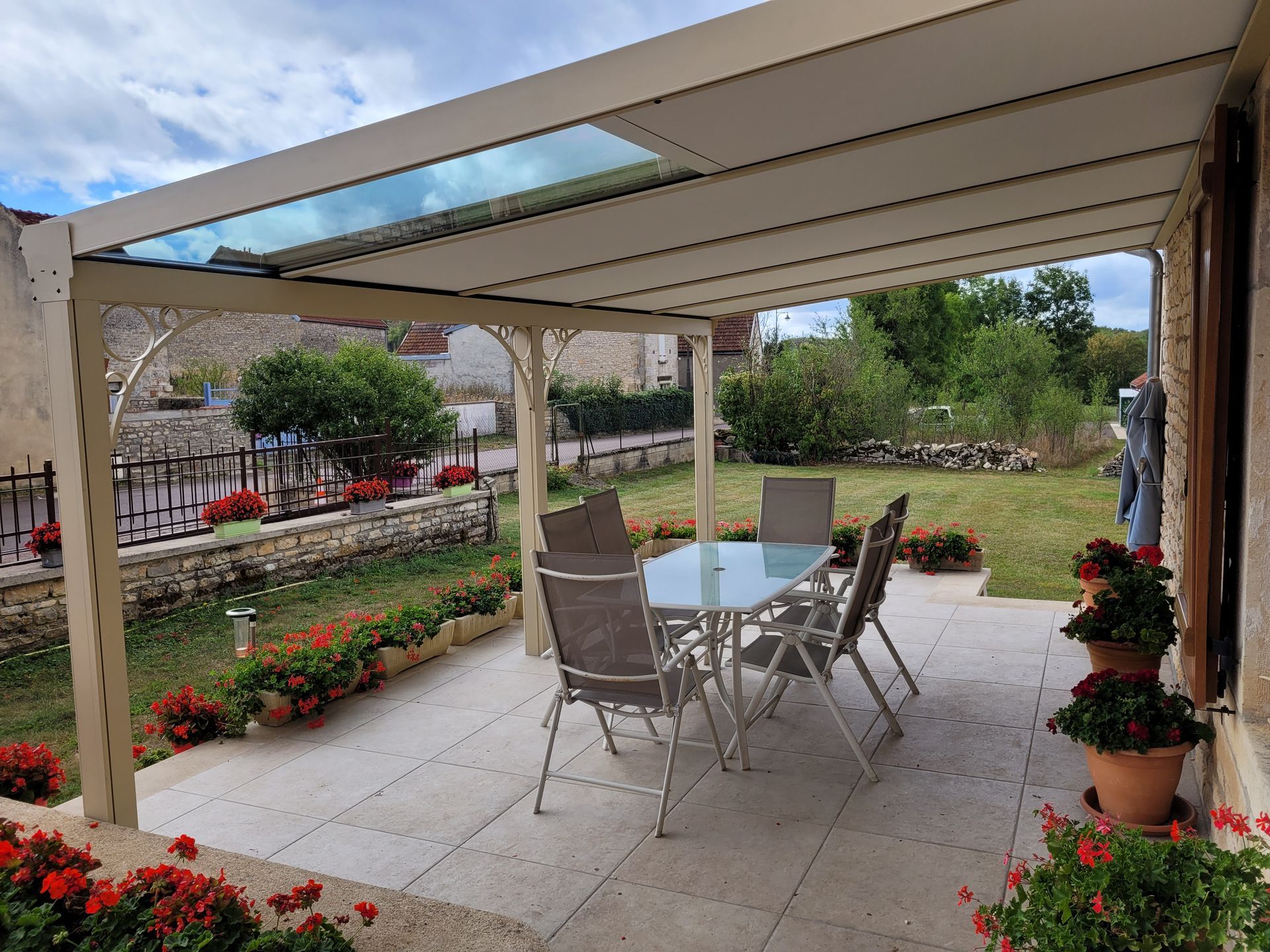Terrasse avec une table et des chaises sous une pergola beige