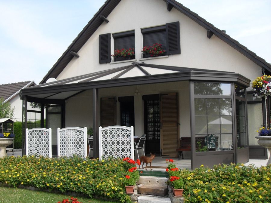 Maison avec une véranda aux cadres bruns