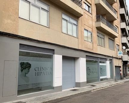 Un edificio con muchas ventanas y un cartel que dice clínica hippatia