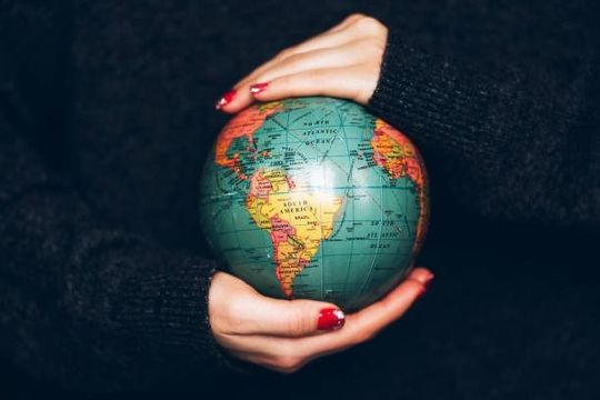 Una mujer sostiene un pequeño globo en sus manos.