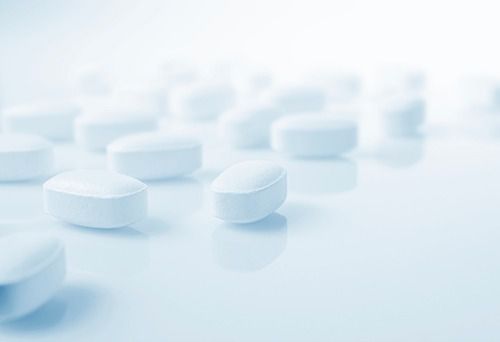 Una fila de pastillas blancas sobre una superficie azul.