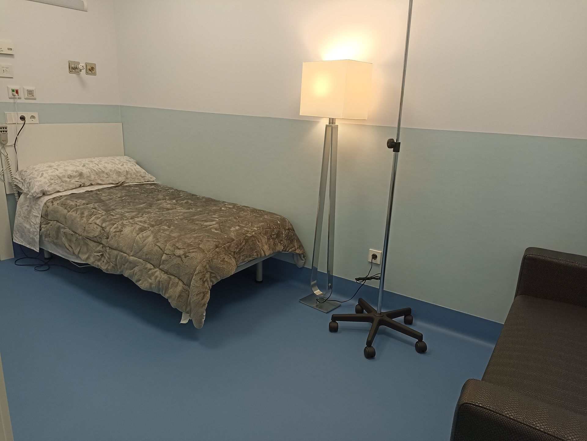Una habitación de hospital con una cama y una lámpara
