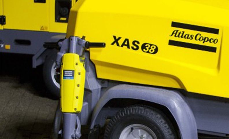 Remorque jaune pour compresseur d'air Atlas Copco XAS 38 avec une roue et un attelage en gros plan