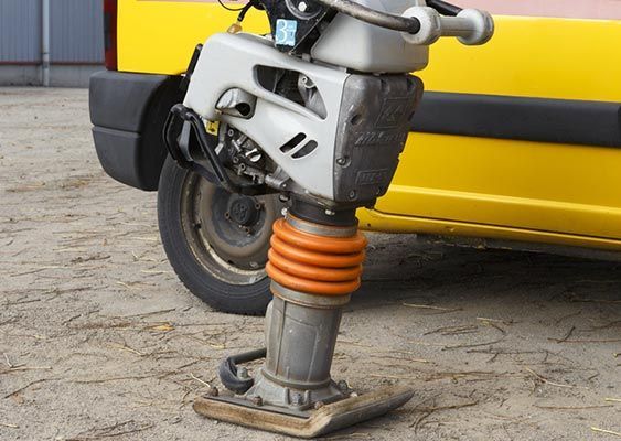 Gros plan sur la roue avant et la suspension d'un bus, à côté d'une carrosserie jaune.
