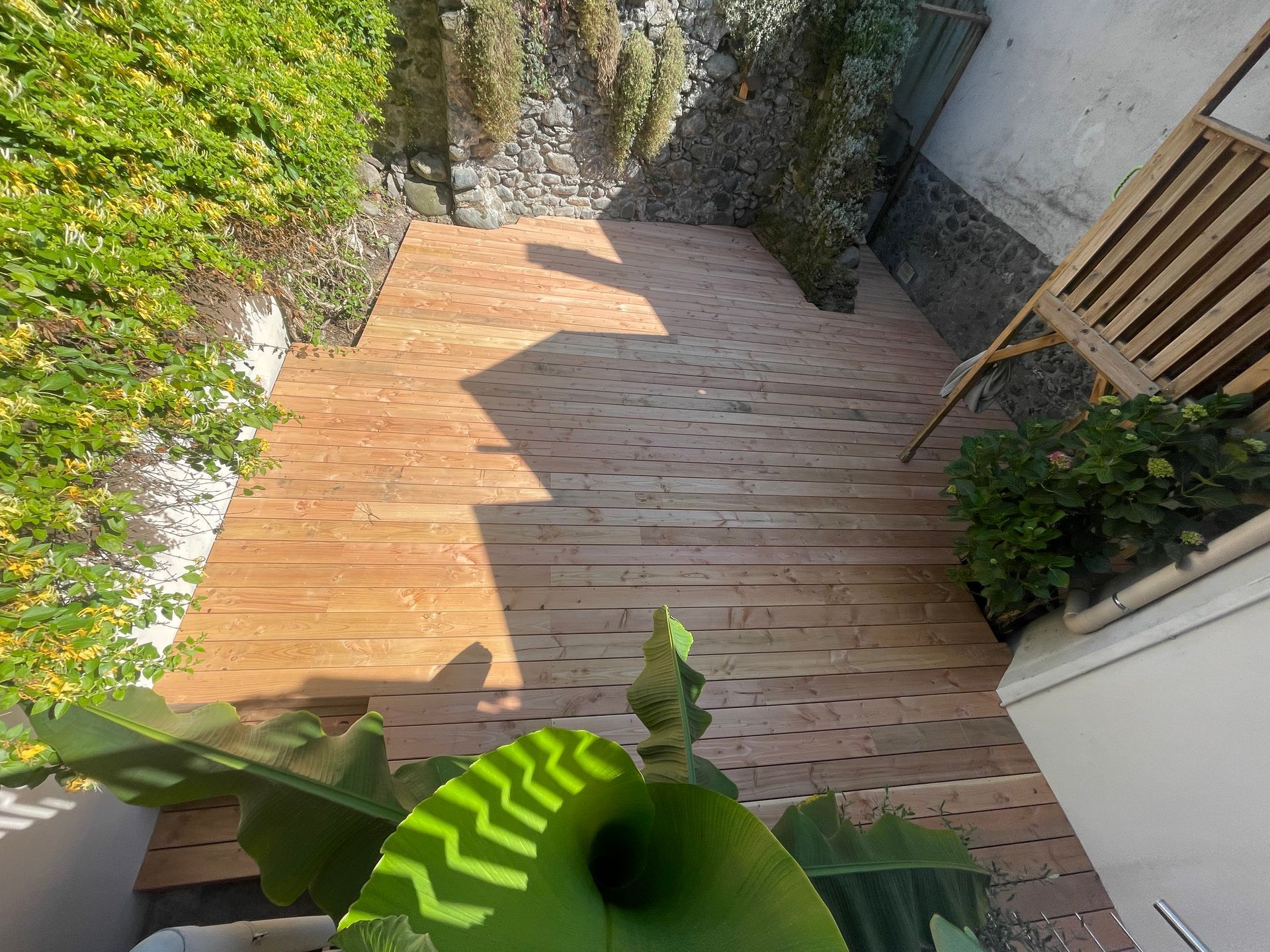 Photo en contreplongée d'une terrasse en bois construite dans une cour intérieure.