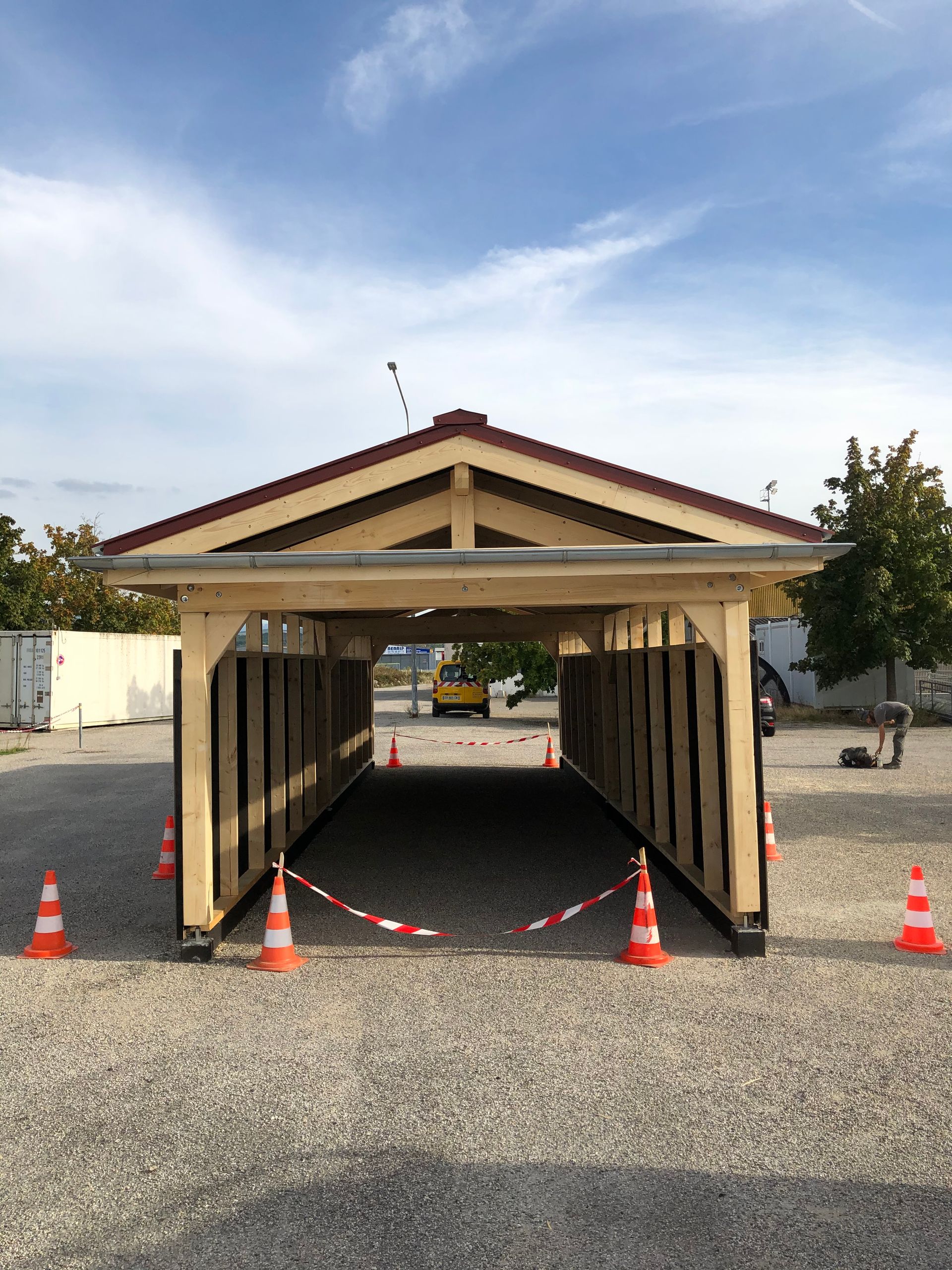Vue de face d'un abri pour protéger un bus avec une charpente apparente.