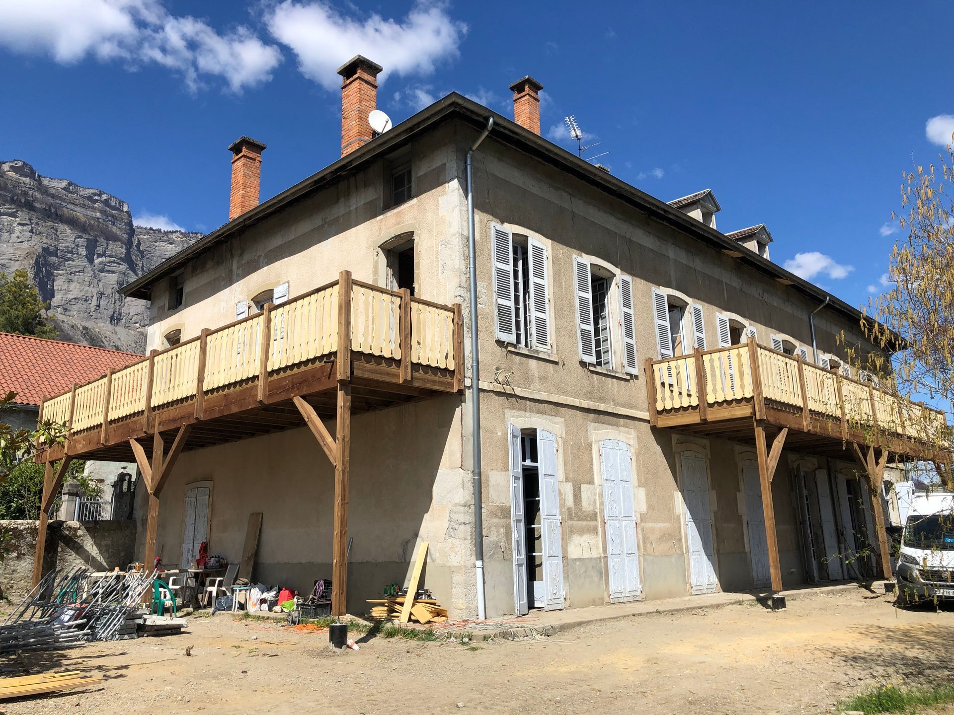 Construction d'un balcon, avec des colonnes et des poutres de soutien, tout en bois.