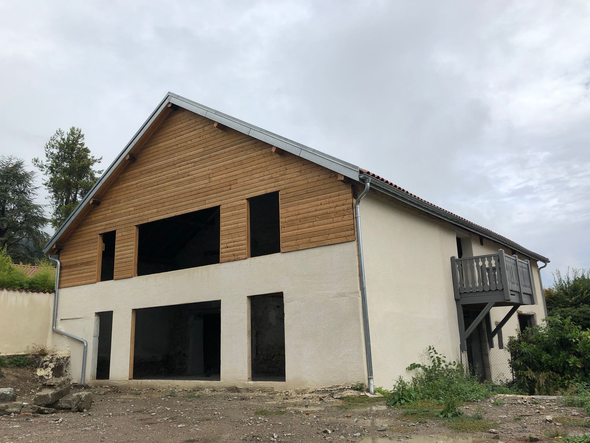 Bardage en bois installé sur la façade de l'étage supérieur d'une maison.