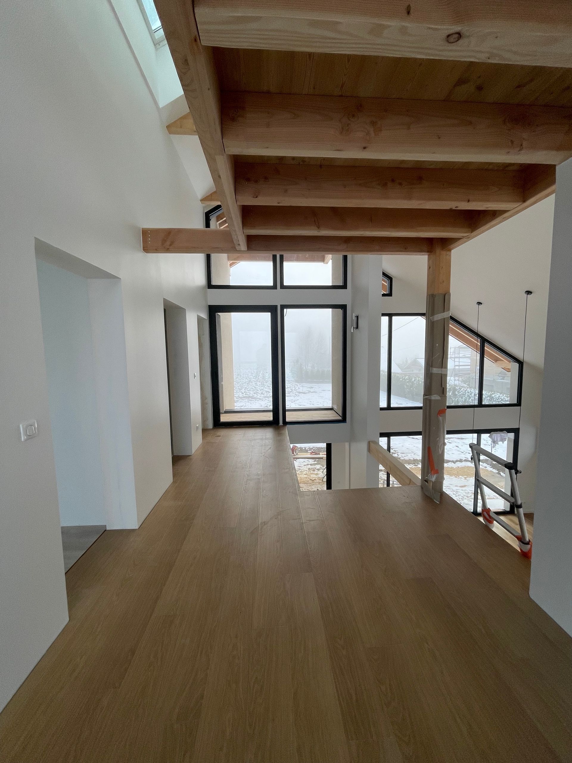 Mezzanine en cours de construction sous un autre angle, avec des poutres et une colonne.