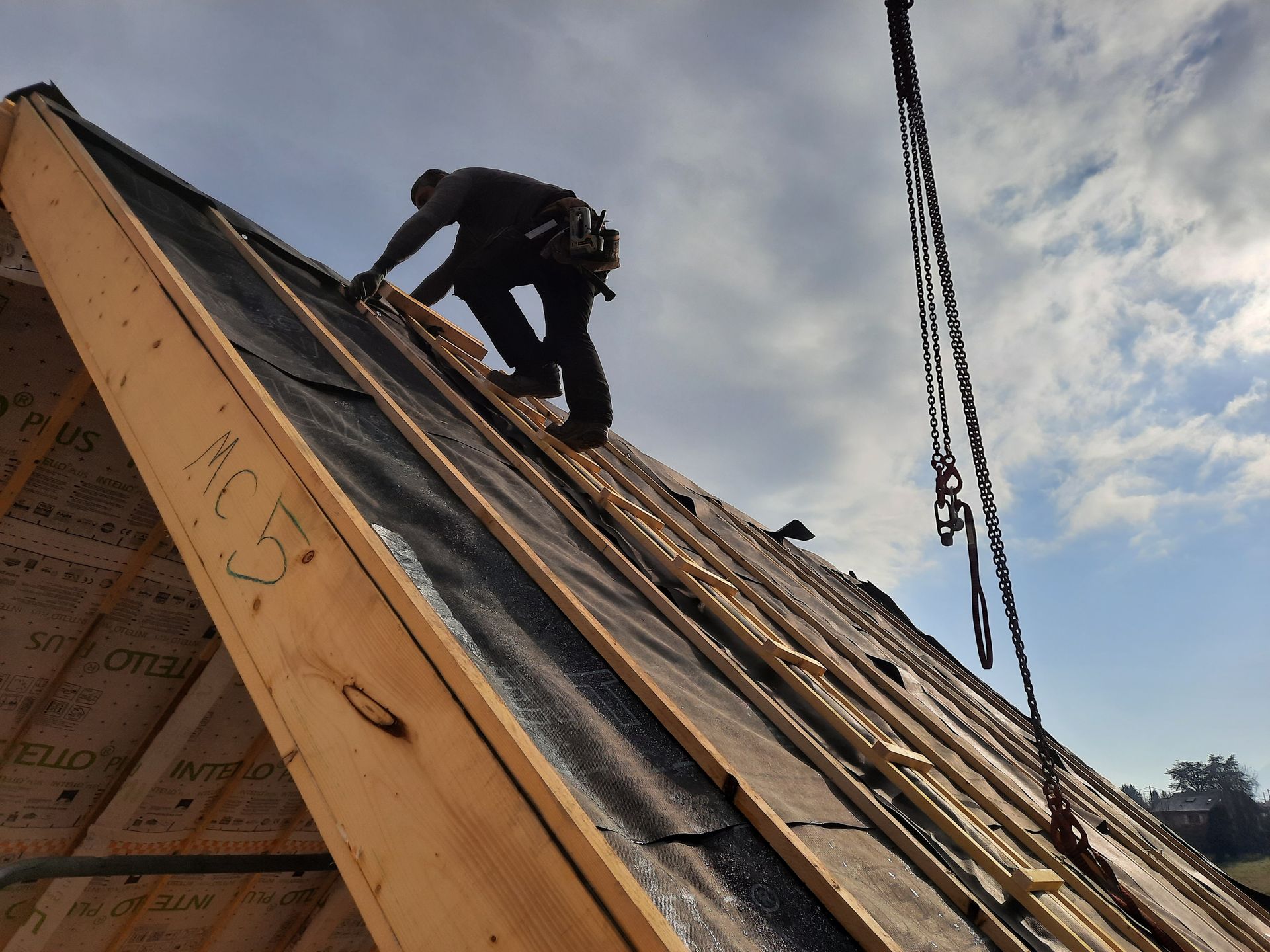 Notre artisan charpentier sur un toit pour des travaux de charpente.