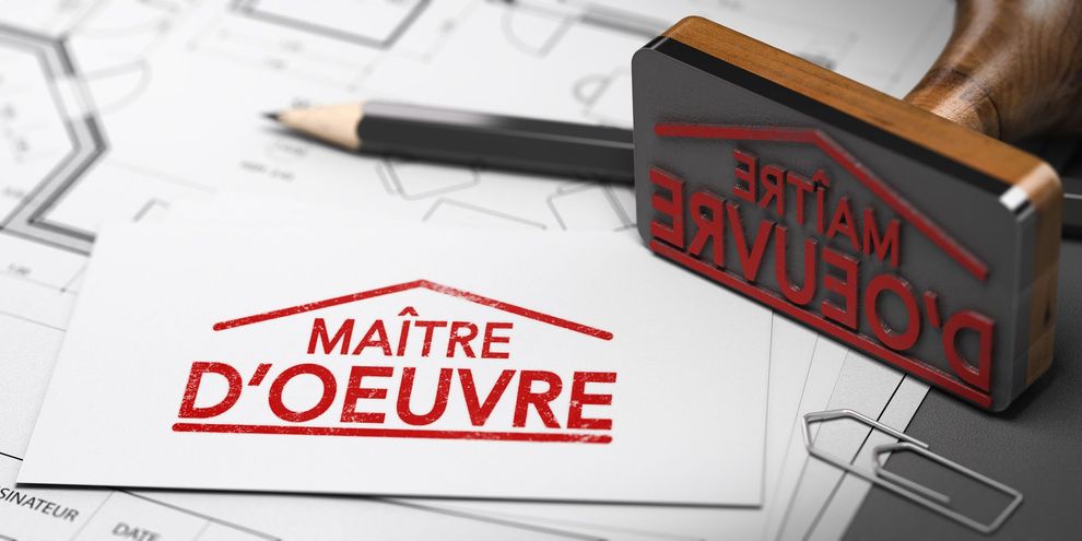 Un tampon et une inscription rouges MAÎTRE D'OEUVRE sont posés sur un bureau à côté de plans d'architecte.
