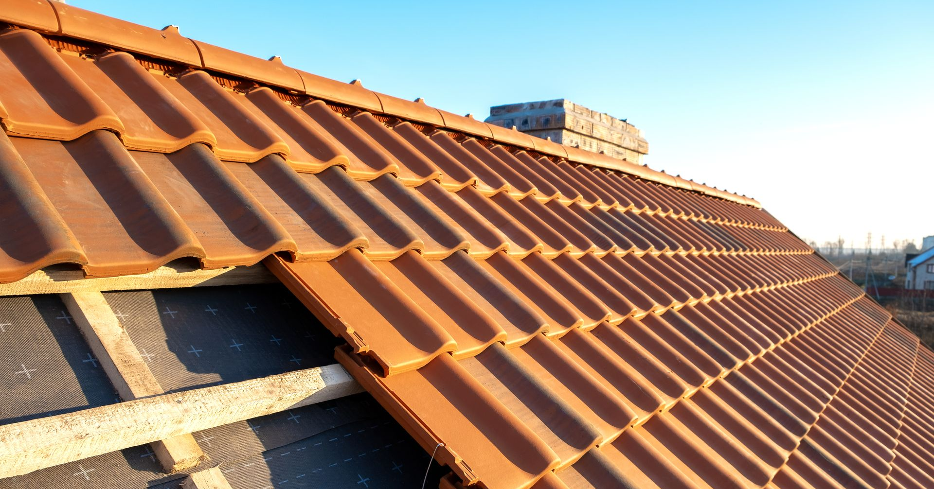 Toiture de tuiles orange en construction.