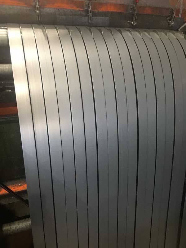 Tiras de metal colgando de una máquina en un entorno industrial.