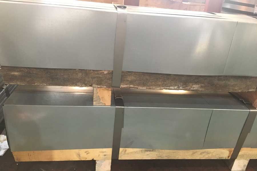 Chapas metálicas flejadas entre sí sobre un palé de madera, listas para ser transportadas.
