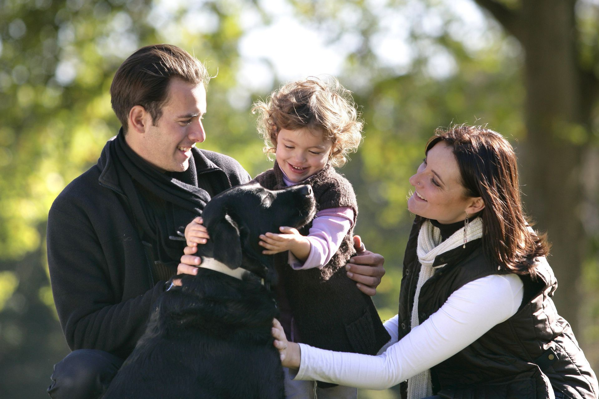 Une famille avec leur chien noir