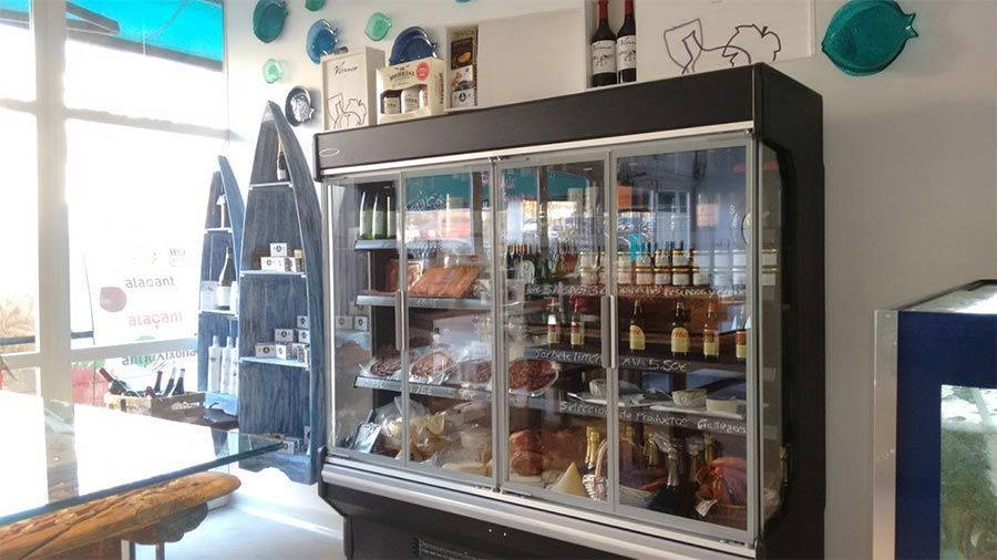 Un refrigerador grande lleno de mucha comida en una tienda.