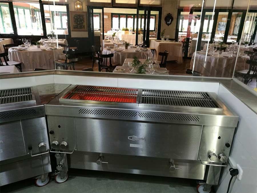 Una gran parrilla de acero inoxidable está en un restaurante.