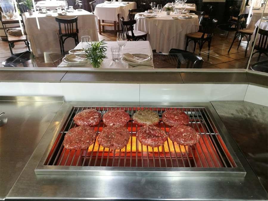 Las hamburguesas se cocinan en una parrilla en un restaurante.