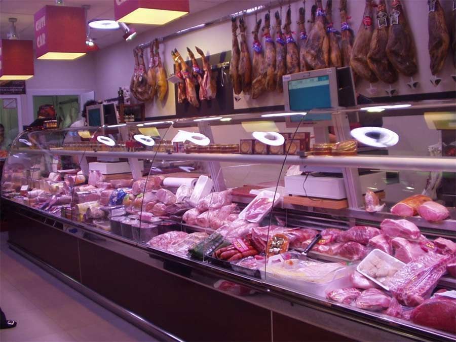 Una vitrina de carnicero llena de carnes y quesos