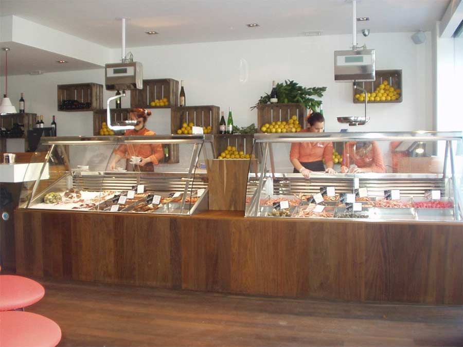 Un par de personas de pie detrás de un mostrador en un restaurante.