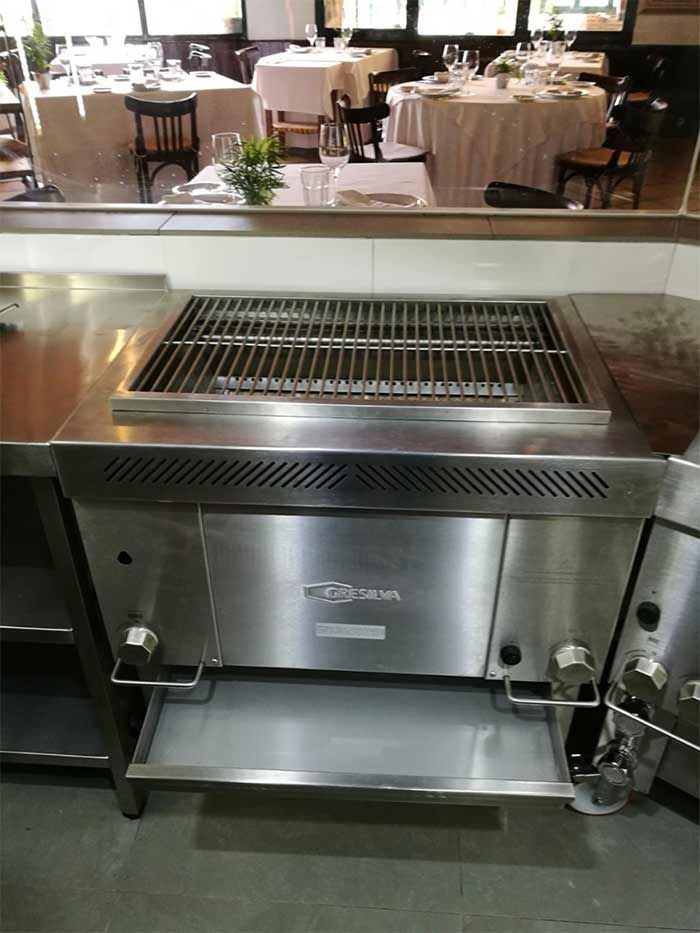 Una parrilla de acero inoxidable está colocada encima de un mostrador en un restaurante.