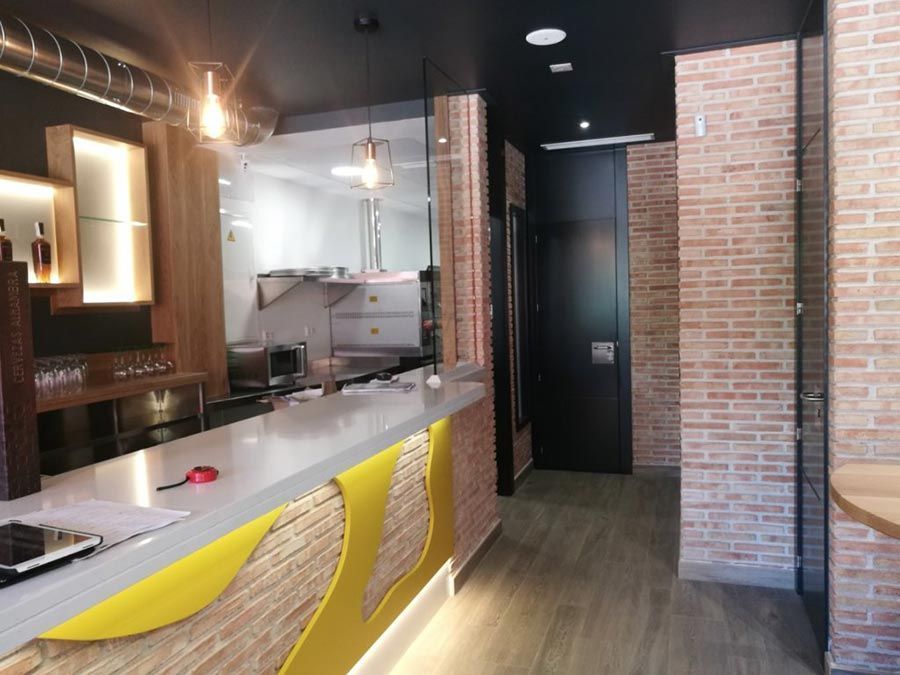 Un restaurante con una pared de ladrillos y un mostrador amarillo.