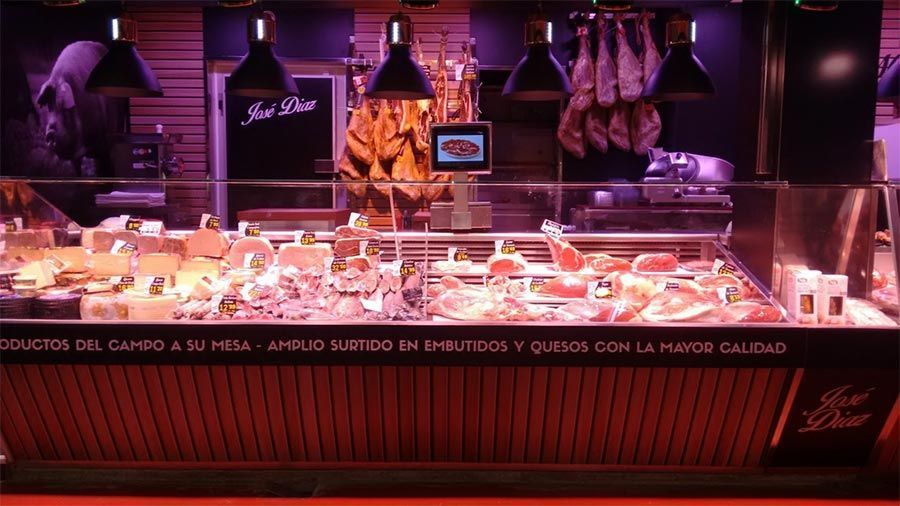 Una vitrina de carnicero llena de carne y queso