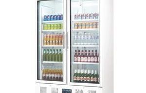 Un refrigerador lleno de botellas y latas sobre un fondo blanco.