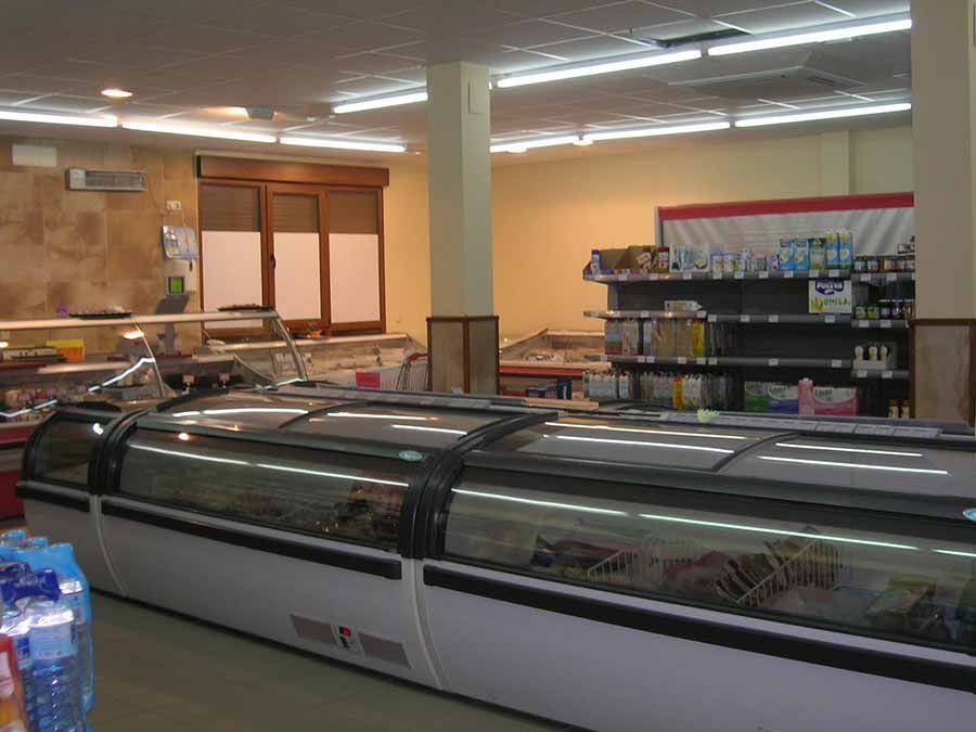 Una tienda de comestibles con muchos refrigeradores y estantes