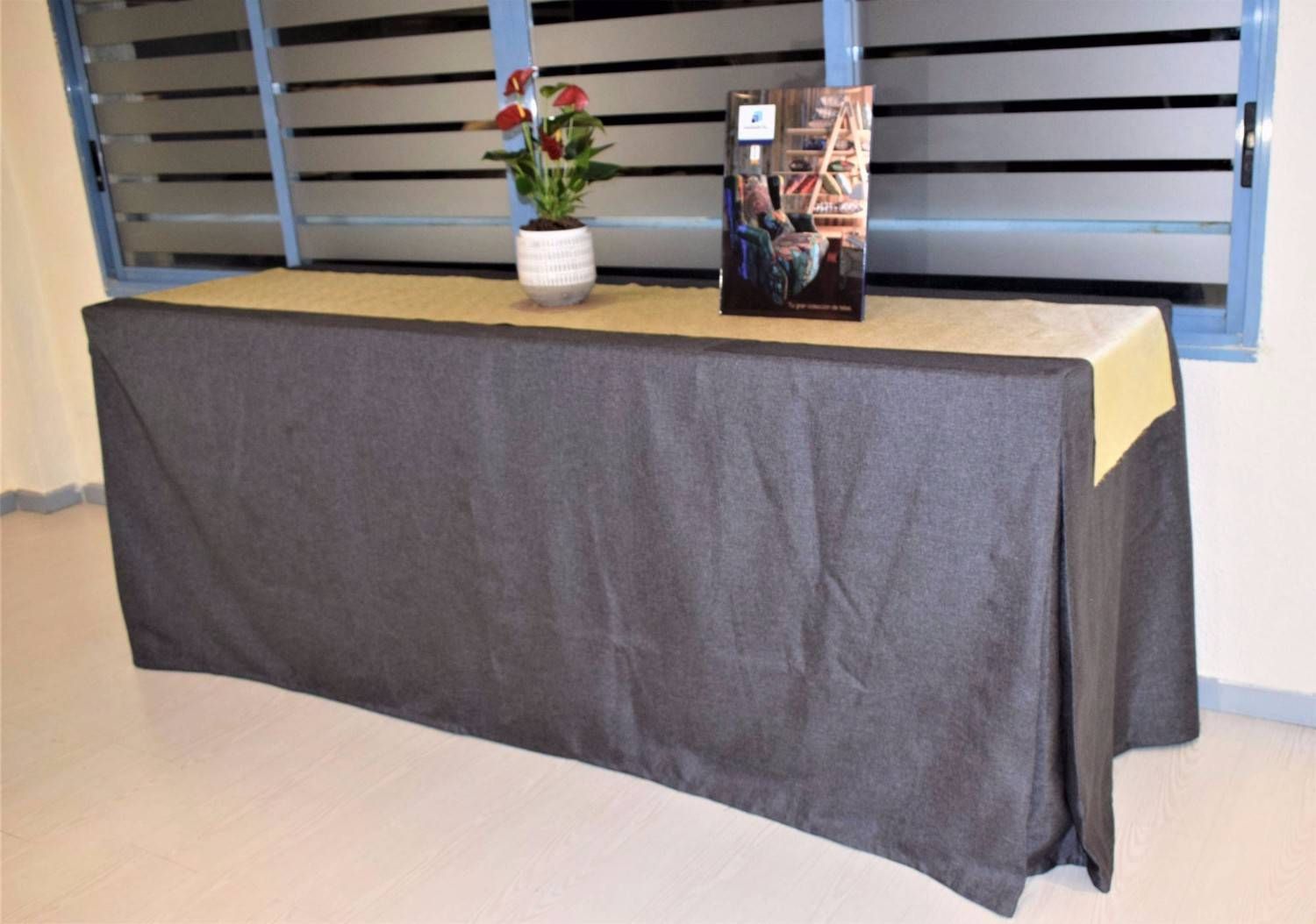 Una mesa larga cubierta con un mantel gris oscuro y