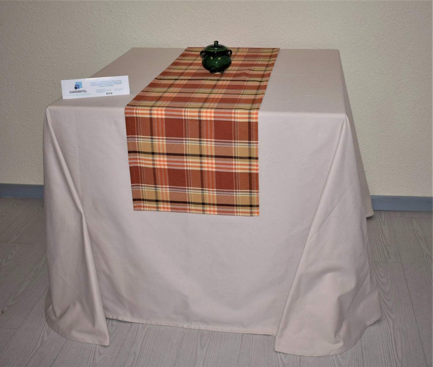 Una mesa cuadrada cubierta con un mantel liso de color beige claro