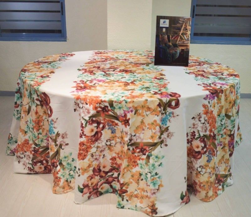 Una mesa redonda cubierta con un mantel blanco con un vibrante