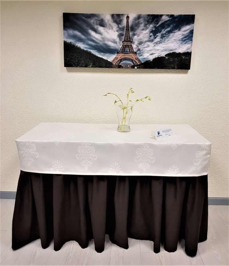 Una mesa rectangular con un mantel blanco