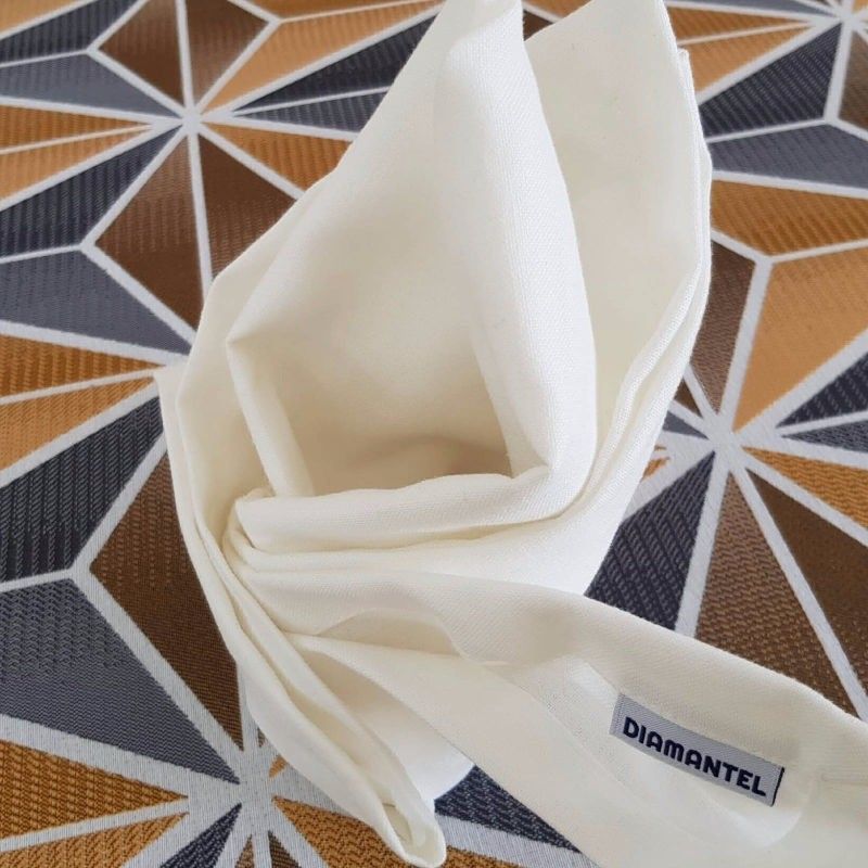 Una servilleta de tela color crema doblada, con una etiqueta