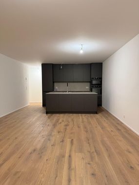 Une salle de bains moderne avec une douche vitrée, un meuble-lavabo mural en bois avec une vasque blanche et un miroir rond.