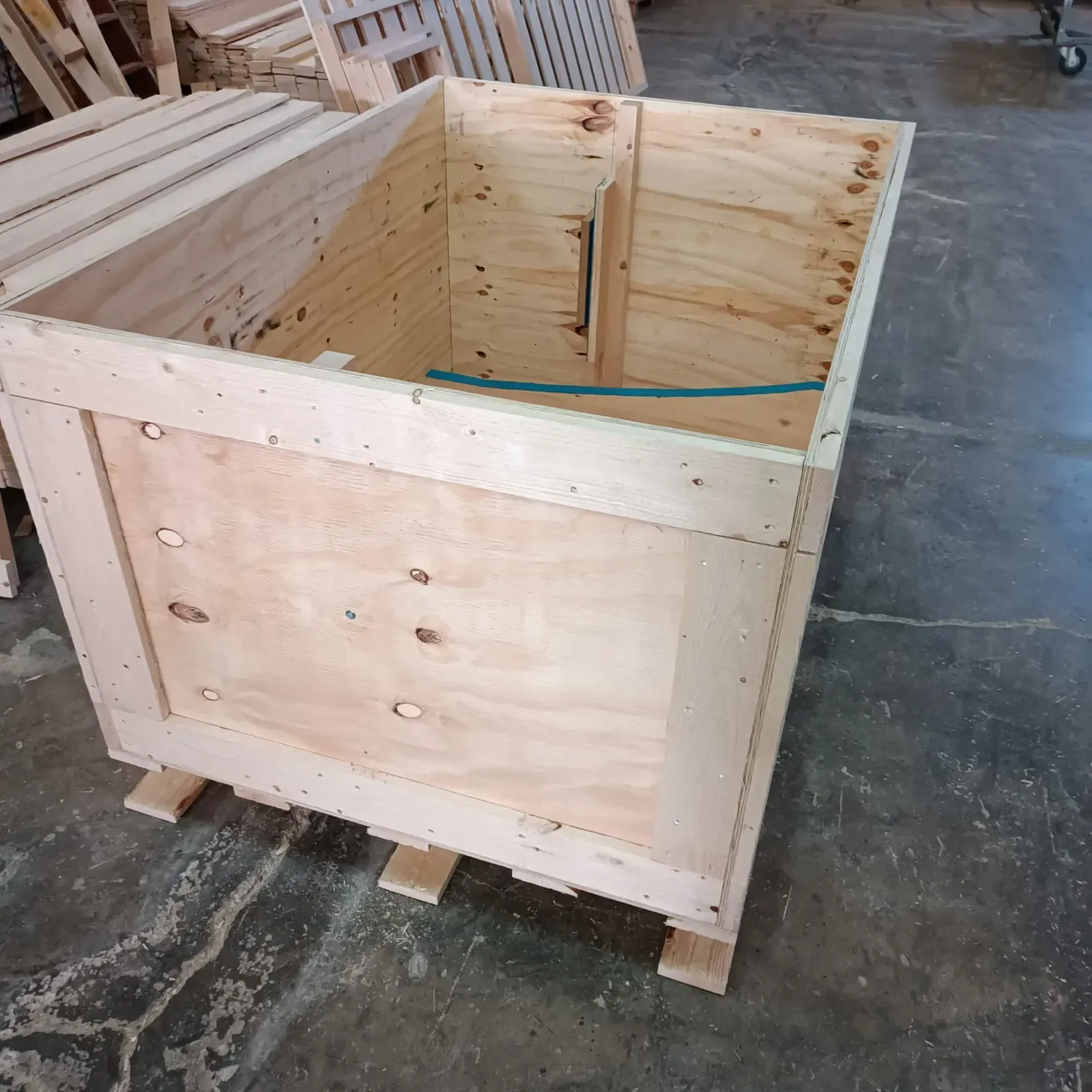 Caja de envío de madera sobre un palé en un almacén.