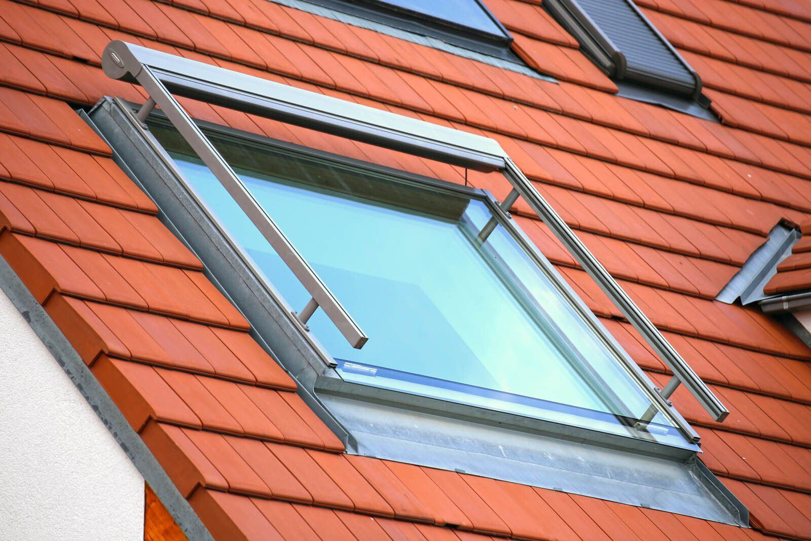Fenêtre de toit sur une toiture avec des tuiles orange