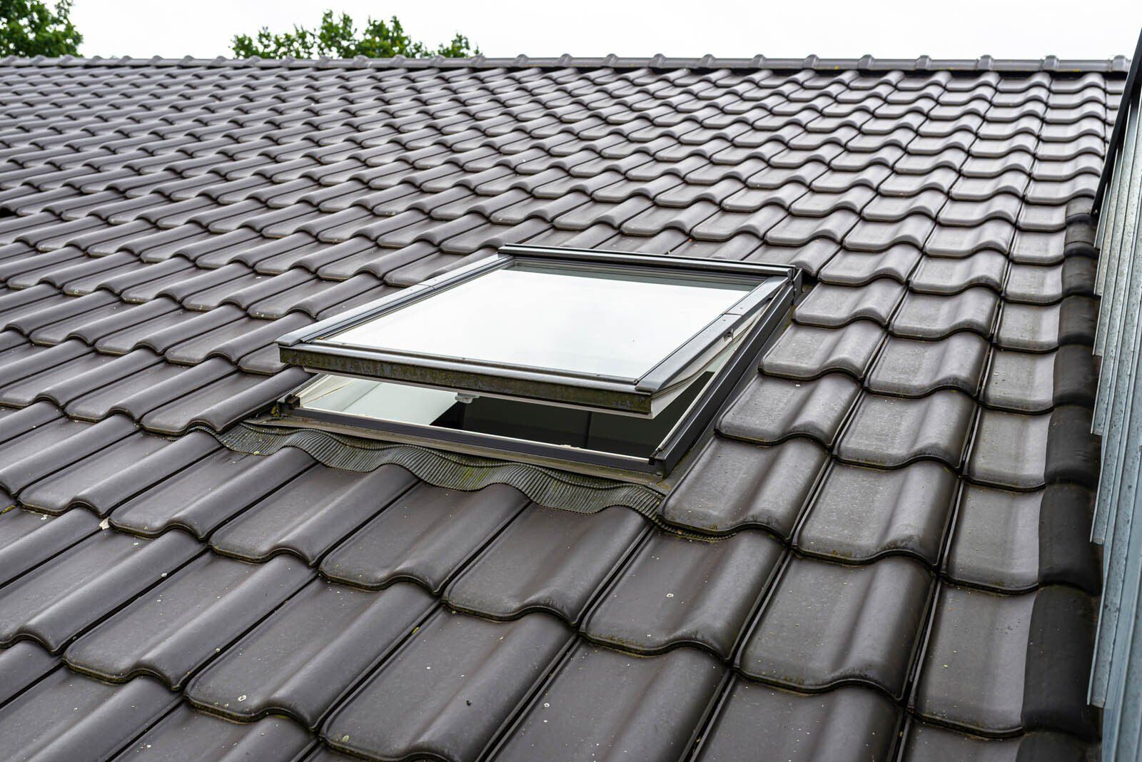 Fenêtre de toit sur une toiture avec des tuiles grises